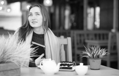 Bir kafede otururken ve tatlı ile çay içme güzel kız