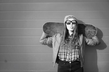 Genç hippi kız bir kaykay sürme. Kızlar kız şehirde bir kaykay ile yürüyüşe. Bahar spor bir kaykay ile sokakta