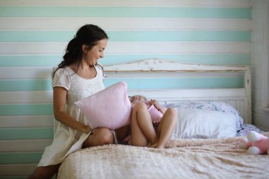 Sabah tembelliği. Anne ve kızı yatak odasında iyi eğlenceler.