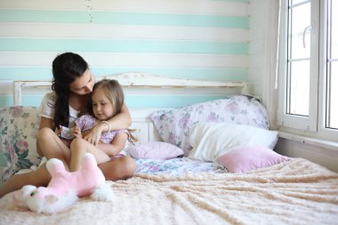 Sabah tembelliği. Anne ve kızı yatak odasında iyi eğlenceler.