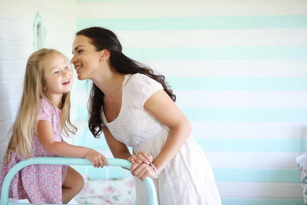 Morning idleness. Mom and daughter have fun in bedroom