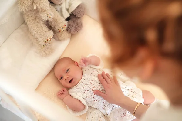 태어난 귀여운 아기가 요람에 엄마를 바라보고 있습니다 — 스톡 사진
