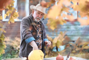 Sonbahar gelenekleri ve Cadılar Bayramı hazırlıkları. Doğada bir ev, masada balkabağından yapılmış bir lamba kesilir..