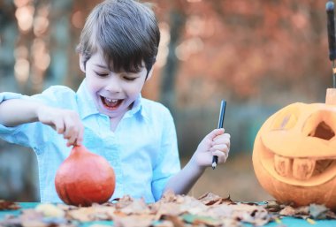 Sonbahar gelenekleri ve Cadılar Bayramı hazırlıkları. Doğada bir ev, masada balkabağından yapılmış bir lamba kesilir..