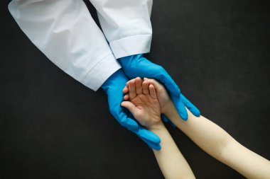 Tıbbi konsept. Eldivenli doktor hastanın elini tutuyor. Doktorun hastalarına moral yardımı. Kardiyolog muayenesi. Salgın.