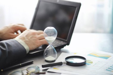 Çalışma zamanı kum saatini sembolize eder. Sigorta müdürü ve bankacı ile ofis masası. Ofis çalışanı masada. Zaman eksikliği kavramı.