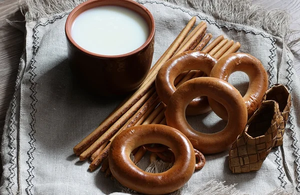 Food milk in a glass straw bagels and pretzels on flax background — Stock Photo, Image