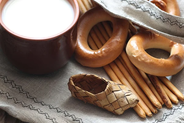 Food milk in a glass straw bagels and pretzels on flax background — Stock Photo, Image