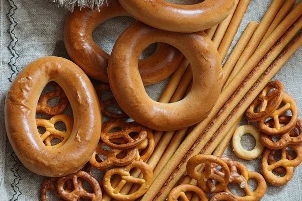 Food milk in a glass straw bagels and pretzels on flax background — Stock Photo, Image