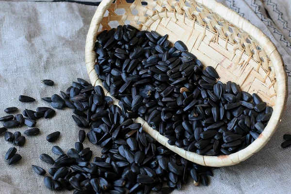 Zonnebloempitten rieten mand op linnen achtergrond — Stockfoto