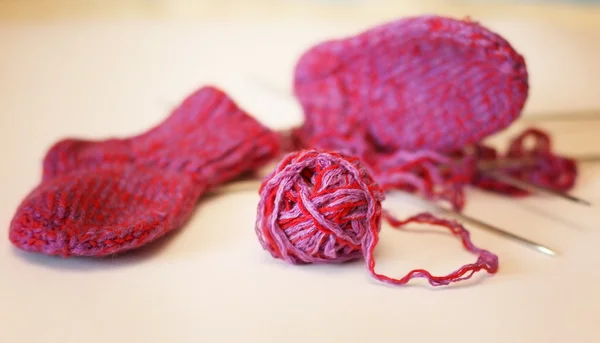 Κόκκινη μπάλα του νήματος βελόνες πλεξίματος να πλέκει κάλτσες — Φωτογραφία Αρχείου