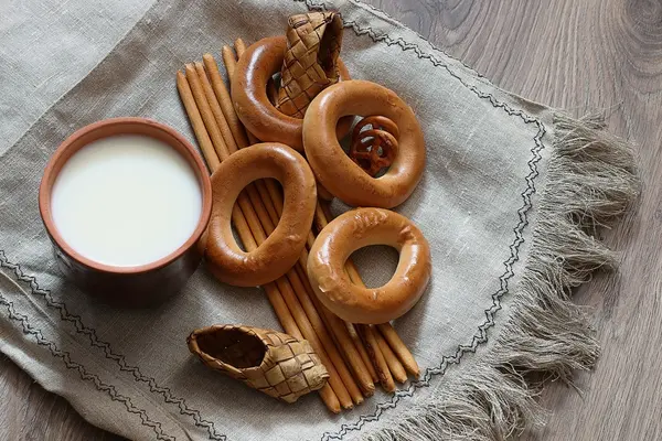 Food milk in a glass straw bagels and pretzels on flax background — Stock Photo, Image