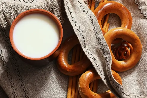 Food milk in a glass straw bagels and pretzels on flax background — Stock Photo, Image