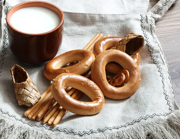 Food milk in a glass straw bagels and pretzels on flax background — Stock Photo, Image