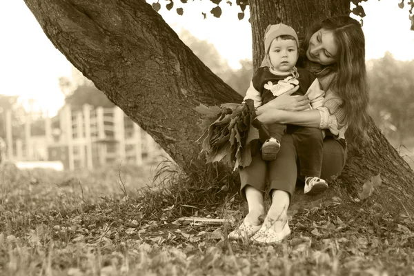 Rusovláska dívka s synem podzimní listí — Stock fotografie