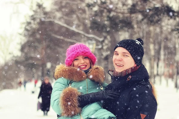 Jovem casal homem carrega uma menina inverno — Fotografia de Stock