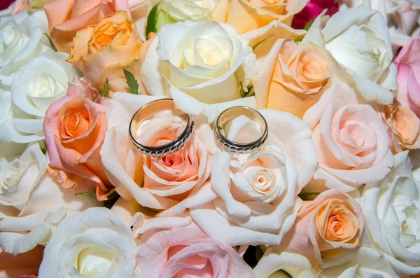 Wedding rings in a bouquet of roses. — Stock Photo, Image