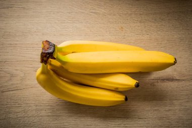 Hafif renkli ahşaptan yapılmış bir yüzeyde muz paketi..