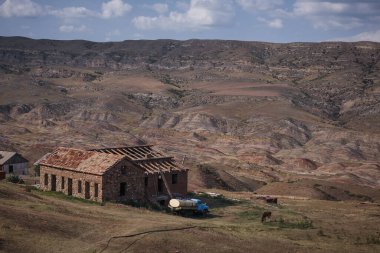David Gareja manastırı yakınlarında terk edilmiş bir evin panoraması. Eski bir tanker ve at görünür durumda. Arka planda ay benzeri bir manzara.