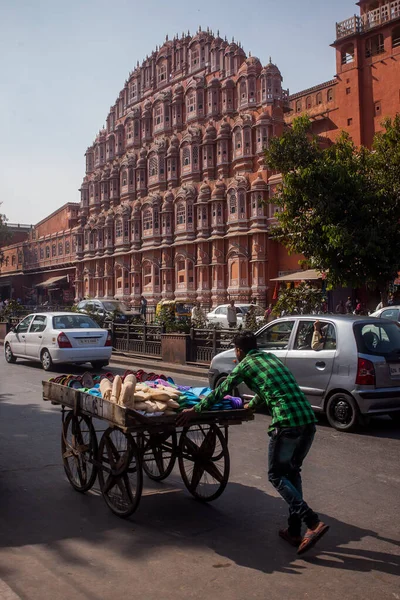 Hawa Mahal, Jaipur - Rüzgarlar Sarayı, sokaktan görüldüğü gibi. Ön planda arabası olan bir adam..
