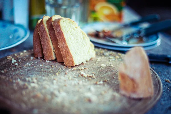 Slices Bread Wooden Board Knives Cutlery Plates Visible Background — Stock Photo, Image