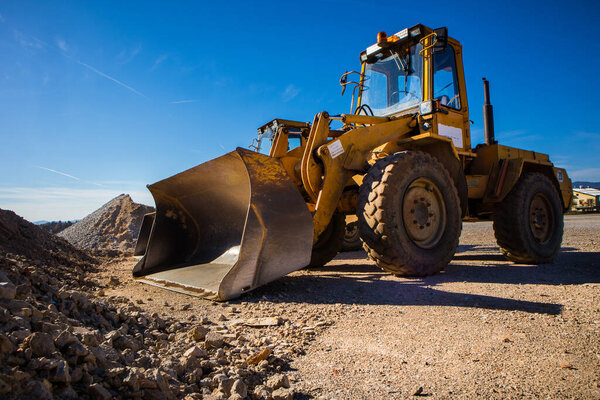 A tractor excavator in the sun. Yellow machine waiting for next duties.