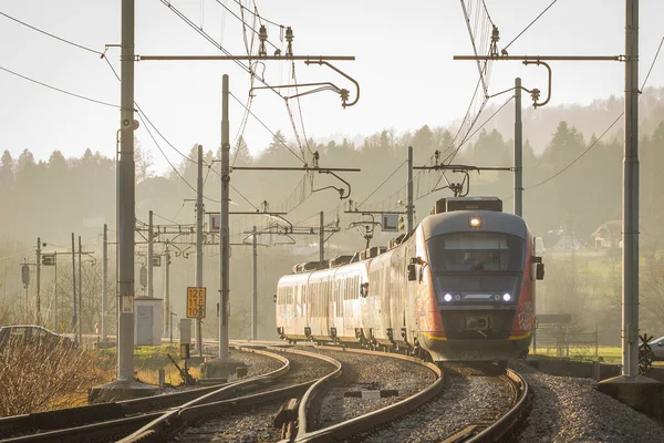 Ein Personenzug Fährt Auf Die Kamera Hinterleuchtet Von Einer Herbstsonne — Stockfoto