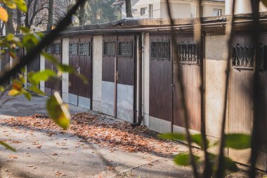 Eski ve sosyalist garajlar ya da Doğu Avrupa 'da 60' larda yapılmış park kutuları. Ağaçların ve dalların arasına bakıyorum..