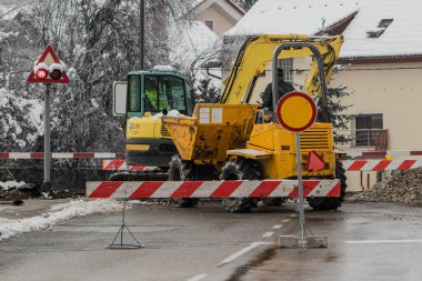 Kışın tren yolu geçidinde çalışıyor. Yatakçıları değiştiriyorum. Koruyucu ve yansıtıcı giysili işçiler.