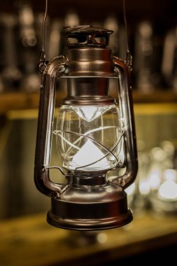Modern LED ışıklandırması olan eski bir metal fener. Arka plandaki diğer lambalar.