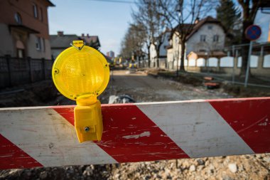 Sarı bariyer ışığı ya da fener kırmızı ve beyaz bir yol bariyerine ya da inşaat alanının önündeki bloğa monte edilir. Bariyer ve sarı fenerle barikat.