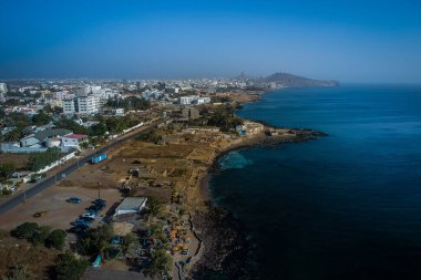 Dakar 'ın Ngor' dan uzak arkaplanda görülen Afrika Rönesans Anıtı 'na doğru havadan görünüşü. Ön tarafta plaj ve bar görünüyor..