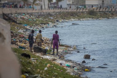 Senegal, Sant Louis 'de üç çocuk denizin kıyısındaki çöpleri kazıyor. Kıyıya vuran atıklarla birlikte korkunç bir su kirliliği. Afrika 'da ekoloji sorunu.