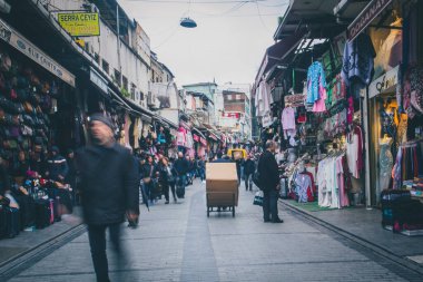 İSTANBUL, TURKEY, 23 Şubat 2018: Ceketler ve diğer giysiler öğle saatlerinde İstanbul 'un her yerinde asılıyken, bazı insanlar makalelere göz atıyorlar.