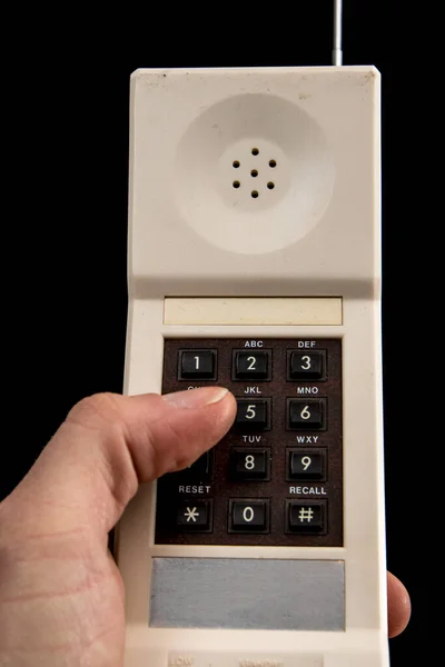 一支80年代的白色老式无绳电话 用手指拨了一个号码 用黑色隔开 可见的大拇指 褐色键盘和银色天线 前沿观点 — 图库照片