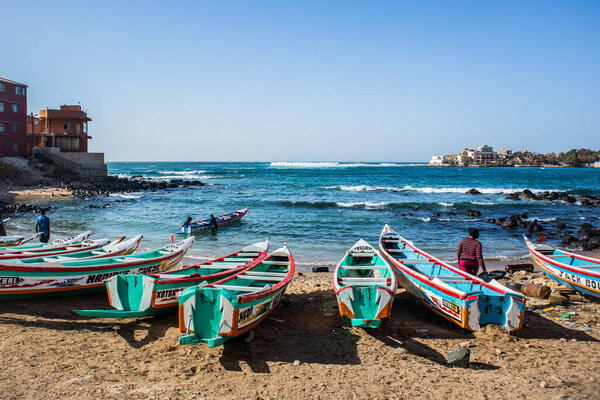 Fishing boats in Ngor Dakar, Senegal, called pirogue or piragua or piraga. Colorful boats used by fishermen standing in the bay of Ngor on a sunny day.