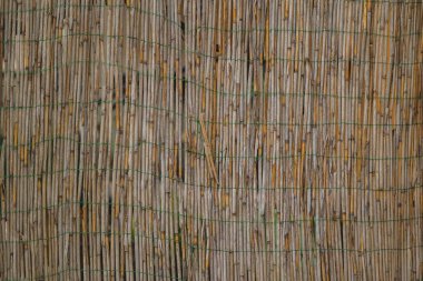 Küçük bambu pipetlerinden yapılmış, birbirine küçük yeşil bir iple bağlanmış. ev bahçesi bambu süslemesi ya da gölgesi.