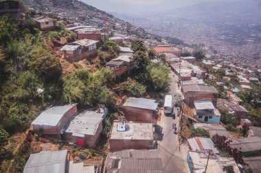 Medellin, Kolombiya 'daki teleferik ya da teleferik görüntüsü. Medellin 'deki gecekondu mahalleleri ve ucuz konutlar. Sizi şehrin ve gecekondu mahallelerinin üstündeki yüksek ovalara götürüyor. Medellin 'in panoramik görünümü.