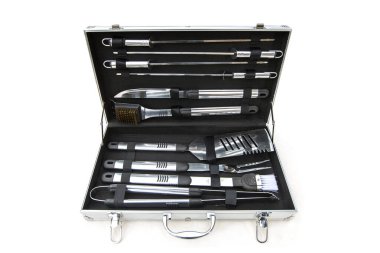 Beyaza izole edilmiş metal bir kutuda barbekü ya da ızgara aletleri var. Maşa, fırça, bıçak, çatal ve benzerlerinden oluşan set.