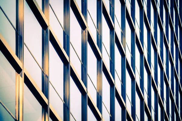 A glass window facade with steel girders. Abstract photo of metal window frames on a skyscraper on a late afternoon or early evening.