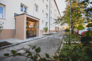 Eski bir sosyalist şehir bloğunun girişi ya da bir banliyö bölgesindeki bir apartman dairesi, taze yeniden inşa edilmiş ve yenilenmiş yeşil ve park yerleri olan eski sosyalist şehir bloğu..
