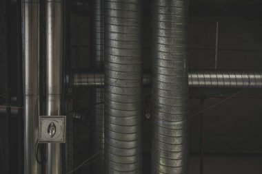 Havalandırma için metal borular ya da bir endüstri salonunun tavanındaki su boruları. Çatıya kanal açmak, direk dikey fotoğraf endüstriyel arka planlar için iyidir..