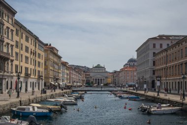 Trieste 'deki ünlü Ponte Rosson, tekneli kanal, güneşli bir günde Antonio Taumaturgo' nun kırmızı köprüsüne ve kilisesine bakıyor..
