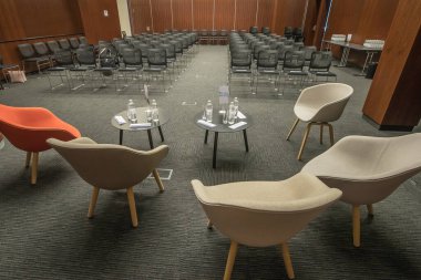 Boş bir konferans salonunda konferans masası için boş sandalyeler. Ziyaretçileri ve konferans sözcülerini ağırlamaya hazır bir salon..