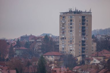 Sırbistan 'ın Belgrad kentindeki tipik sosyalist şehir bloğu, bulutlu ve puslu bir sonbahar gününde diğer alçak binalarla çevrili.