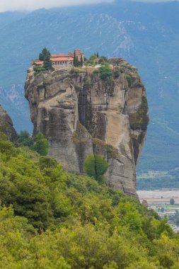 Kutsal Üçlü Manastırı Panoraması. Güzel manzaralı panoramik manzara, Meteora, Thessaly, Yunanistan ve Avrupa 'da bulutlu bir günde dev bir taş sütunun tepesinde antik geleneksel Yunan binası.
