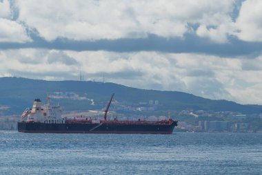 Türkiye 'de bulutlu bir günde Çanakkale Boğazı' ndan geçen büyük bir kargo gemisi veya uçak gemisi.
