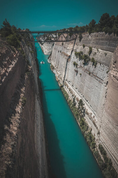 Коринфский или Коринфский канал в Греции. Узкий водный путь, соединяющий Ионическое море с Эгейским морем. Узкий проход воды, вырезанный в скале в солнечный день.