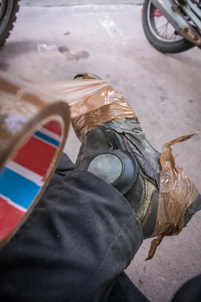 Person Taping His Broken Used Leather Motorcycle Boots Brown Tape — Stock Photo, Image