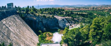 Güneşli bir günde İspanya 'nın Katalunya kentindeki Tremp şehrine yakın Talarn Gölü' ndeki bir hidroelektrik santralinin panorama resmi..